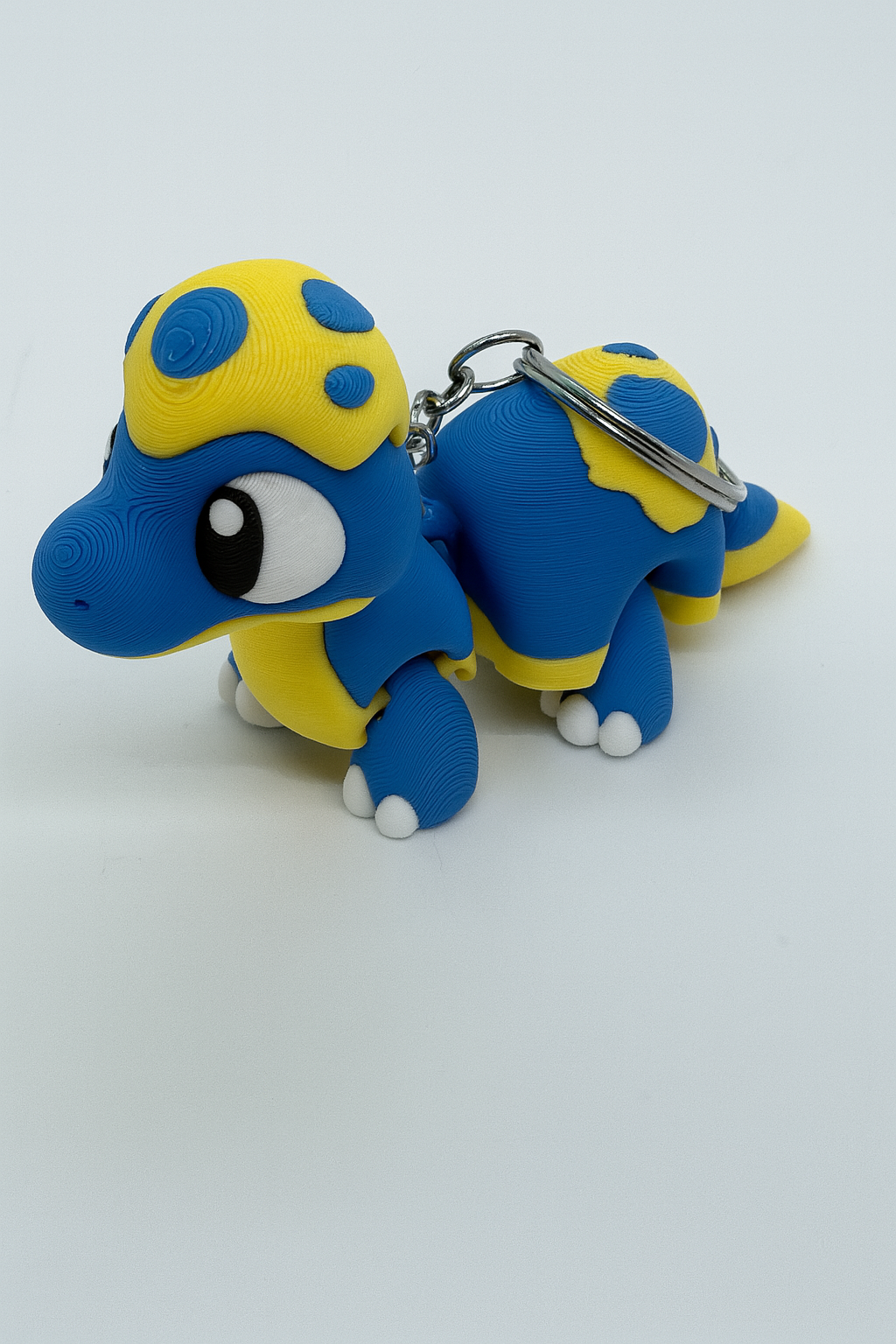 Flexible Baby Dinosaur Keychain: Articulated Blue & Yellow Dino Fidget Toy for Dinosaur Lovers