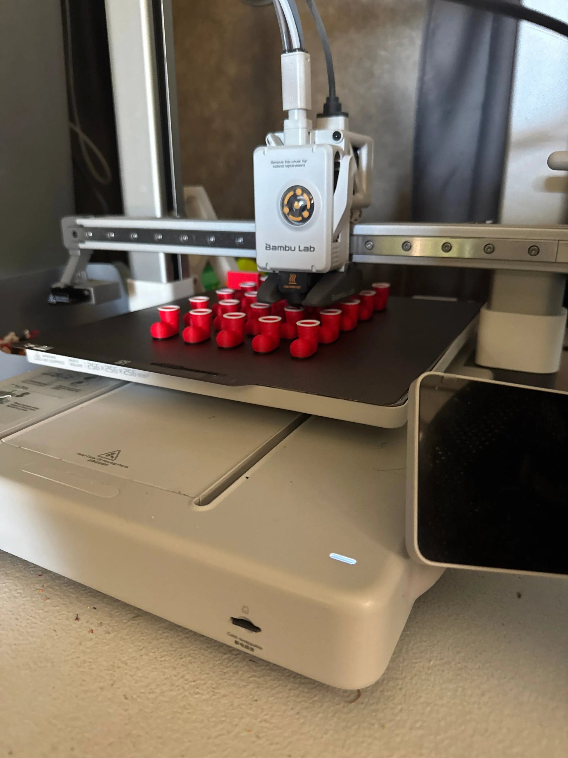 3D printer with red Santa shoes on a metallic surface