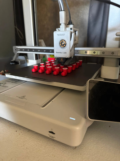 3D printer with red Santa shoes on a metallic surface