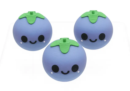 Three blueberry-shaped toys with smiling faces on a white background