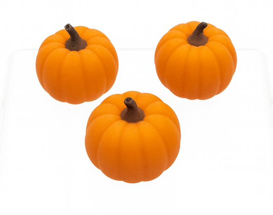 Three small orange pumpkins with brown stems on a white background